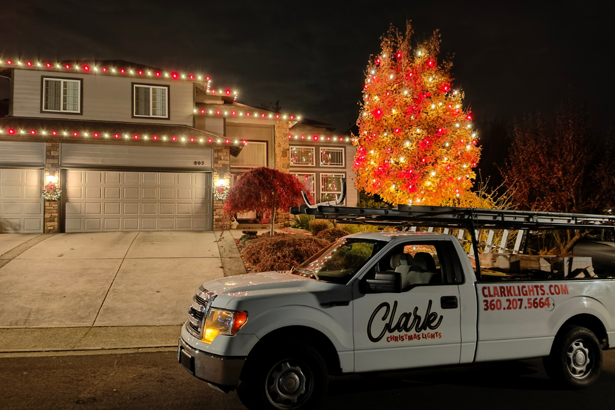 clark christmas lights work truck in front of a house lit with lights